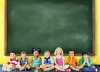 Young students seated in front of whiteboard