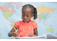 Student writing in front of a world map